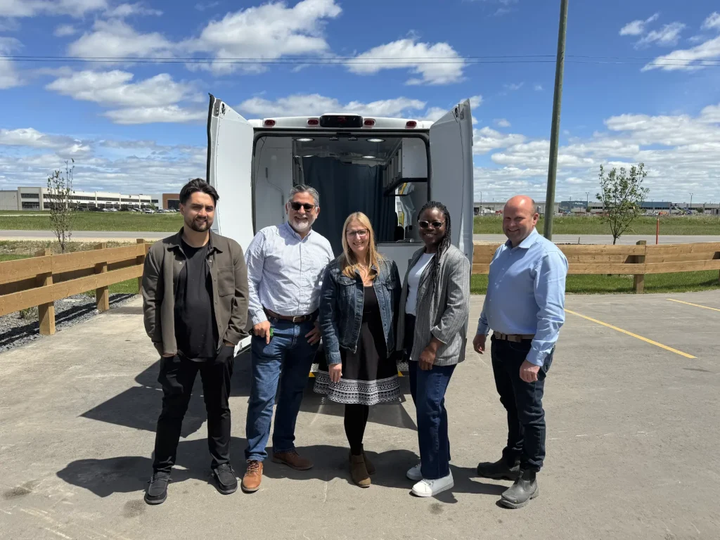 Carrie McDonald with members of the MoveMobility team and World Trade Centre Winnipeg during a visit to MoveMobility's new facility