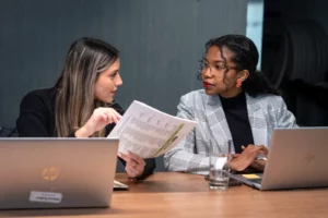 WTC Winnipeg staff, Milena Audino, Associate Trade Advisor looking over documents with Tiphanie Tsihoarana, Executive Assistant.