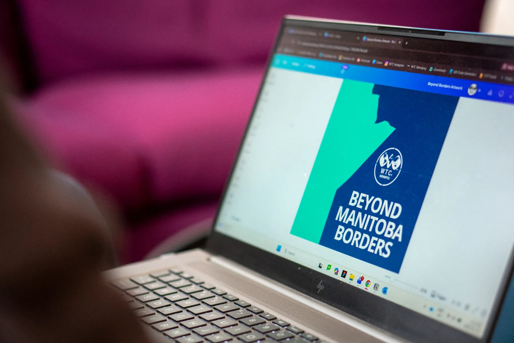 Close-up of laptop screen showing a graphic for Beyond Manitoba Borders.