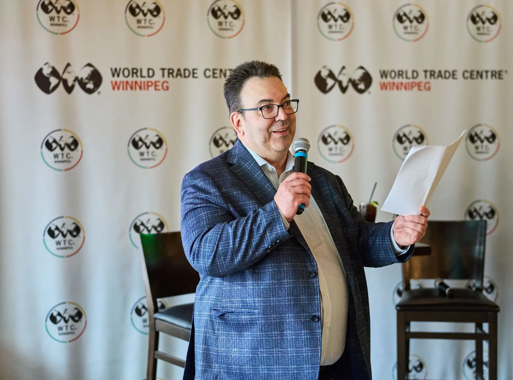 Andre Brin, CEO of WTC Winnipeg, on stage with microphone at WTC Talks.