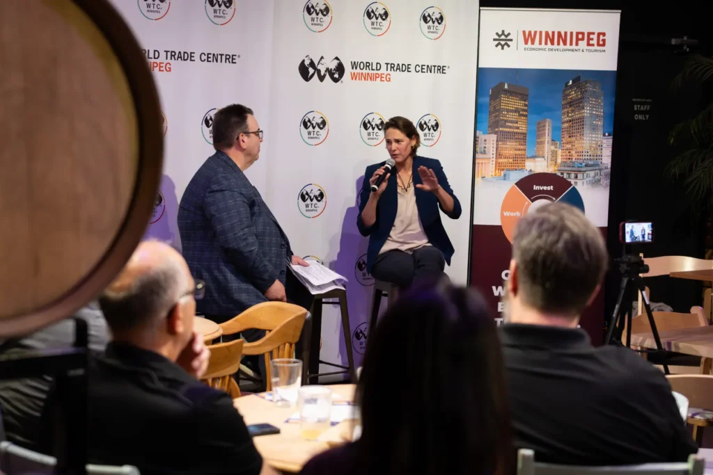 Camila Bellon, CEO of Easton Automation speaking at a WTC Talks event, sharing the stage with André Brin, CEO of WTC Winnipeg.